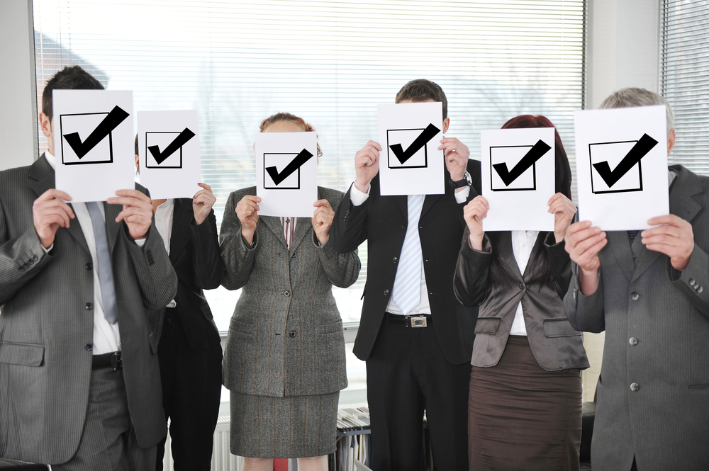 Successful team holding check mark vote sign