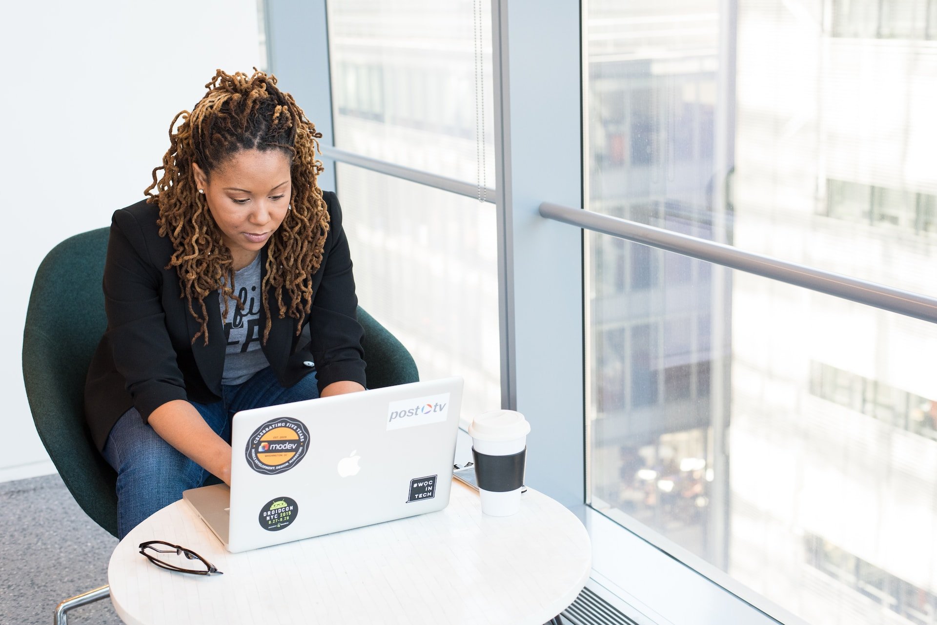 business woman sits at her laptop by a window