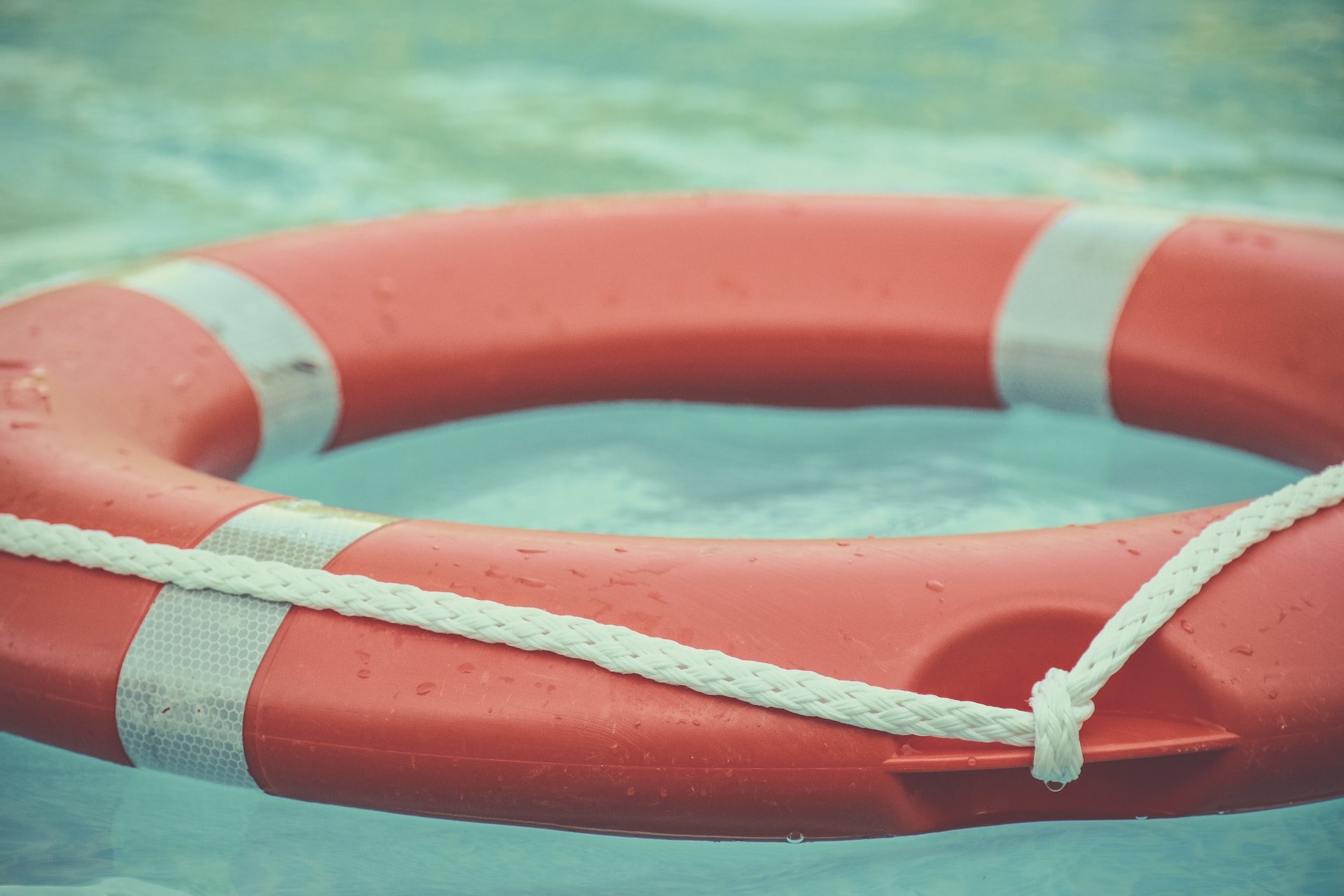 A red and white life preserver floating in water